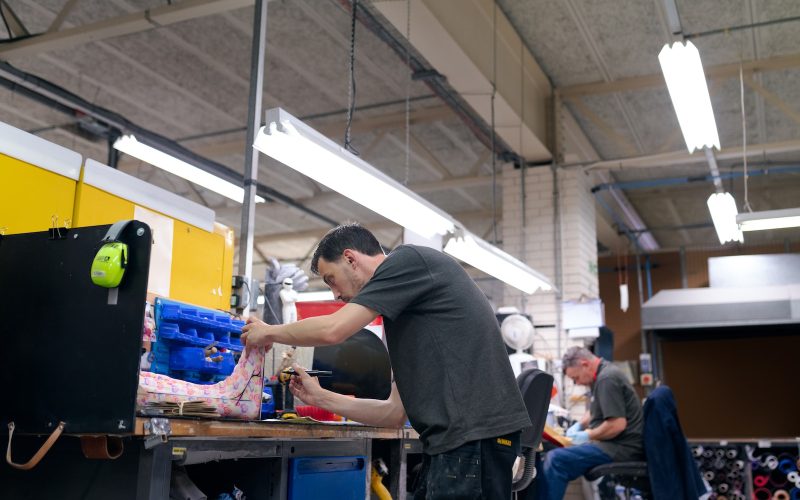 man in black t-shirt and blue denim jeans standing in front of blue plastic container